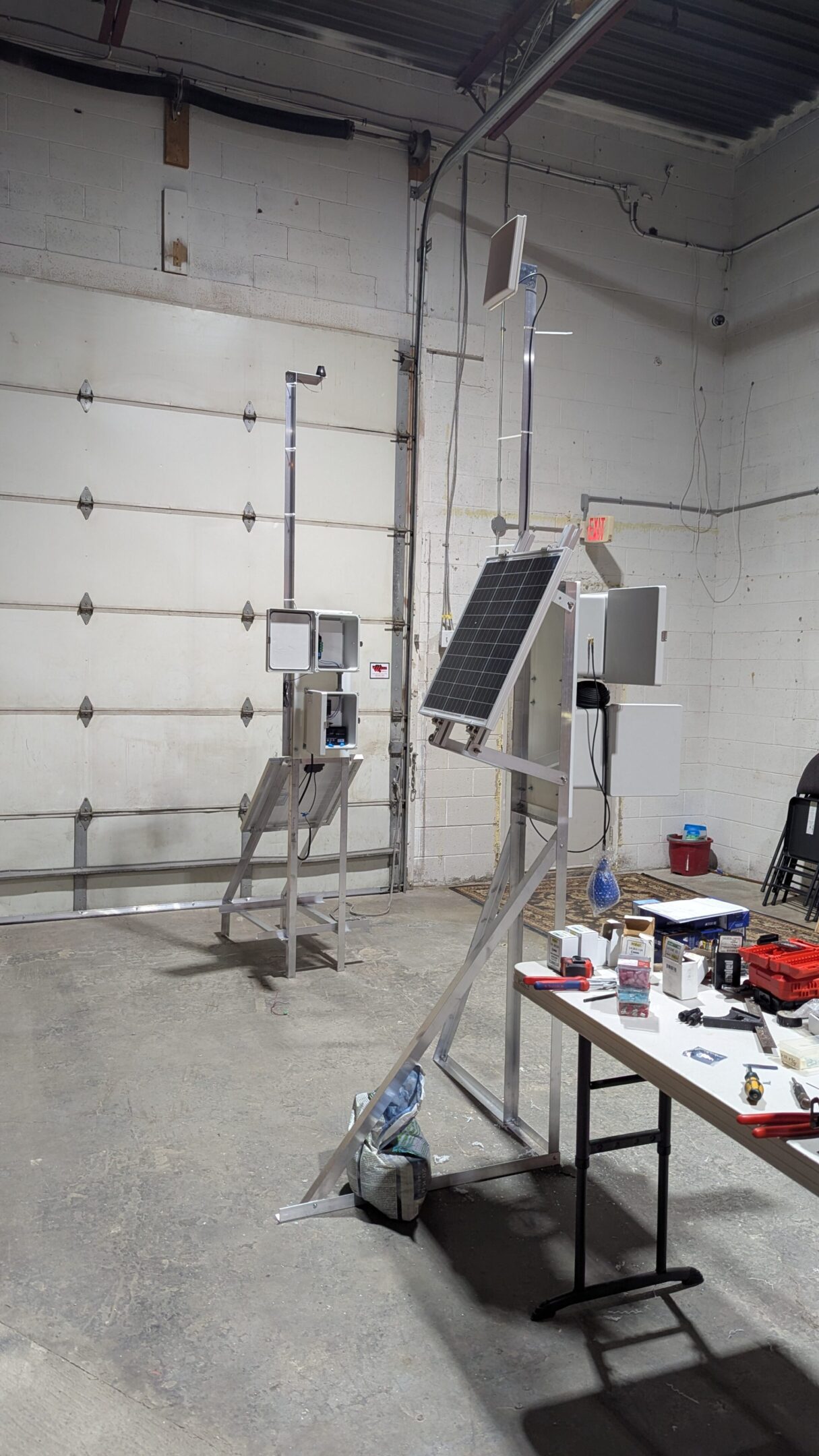 Robotic arms with solar panels in a workshop setting.